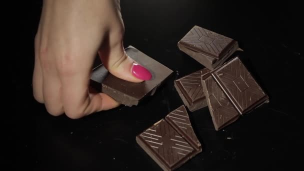 La mujer rompe la barra de chocolate negro. Primer plano. Movimiento lento
 - Imágenes, Vídeo