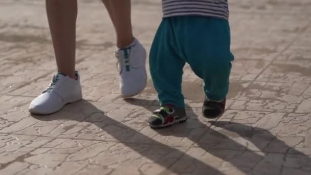 Legs of the mother and little kid that walk in slow motion. - Materiał filmowy, wideo