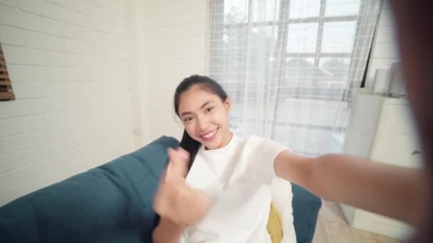 Młody Asian nastolatek kobieta Vlog w domu, Kobieta za pomocą smartphone co Vlog wideo do mediów społecznościowych w salonie. Lifestyle kobieta zrelaksować się rano w koncepcji domu.  - Materiał filmowy, wideo