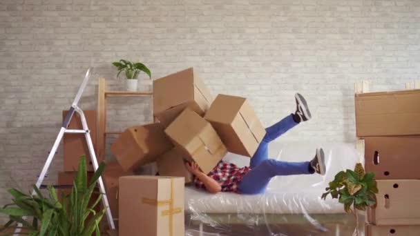 Mann mit großen Schachteln in der Hand fällt auf das Sofa - Filmmaterial, Video