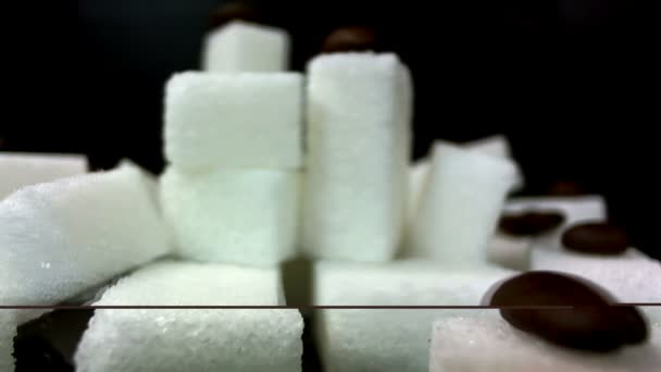 Een stapel van suiker stukken draait tegen een zwarte achtergrond - Video