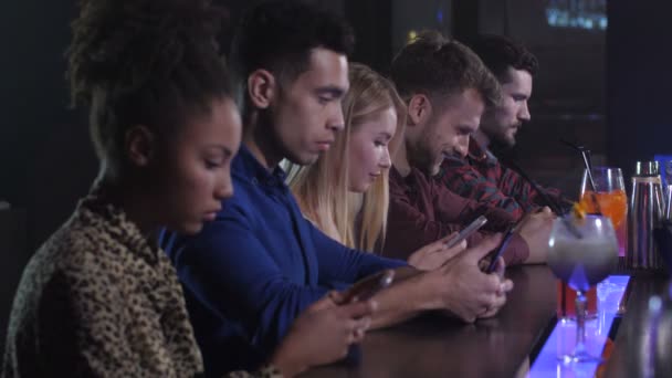 Ομάδα φίλων δικτύωση στα τηλέφωνα σε νυχτερινό κέντρο διασκέδασης - Πλάνα, βίντεο
