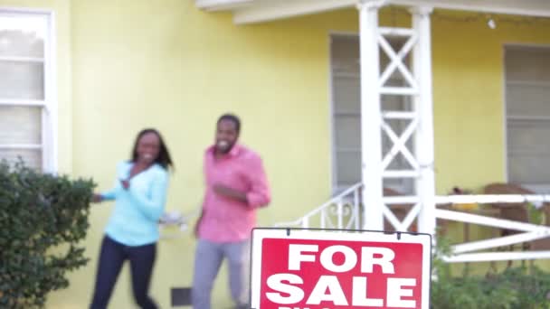 Couple outside house with sold sign - Metraje, vídeo