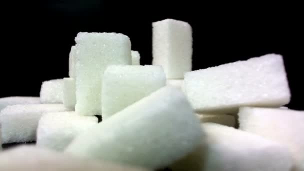 Un mucchio di pezzi di zucchero ruota su uno sfondo nero
 - Filmati, video