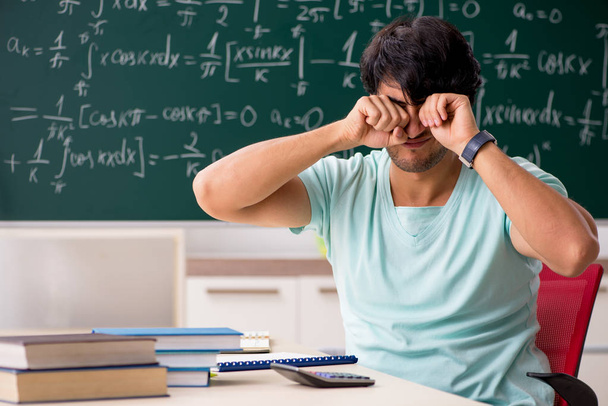 Nuori miespuolinen opiskelija matemaatikko edessä liitutaulu
  - Valokuva, kuva