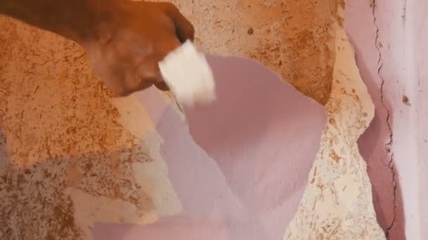 El hombre limpia o pela la pared de papel pintado viejo
 - Imágenes, Vídeo