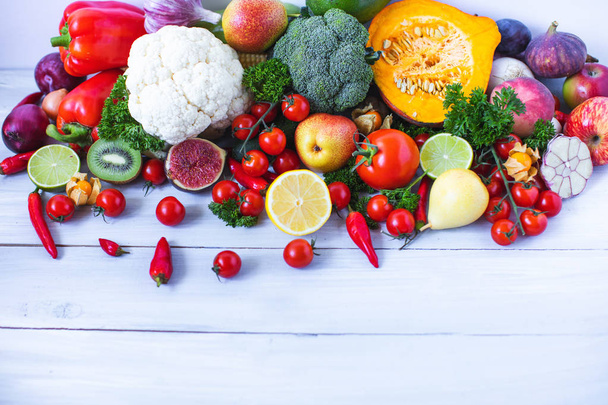 Various fresh vegetables and fruits on a wooden background, top view, copy space.  - Foto, Imagem