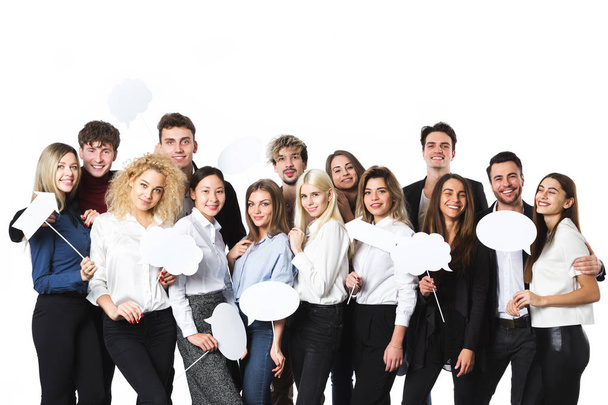 Group of young beautiful women and men in casual wear with clouds of thoughts tags in hands isolated on white background. - Photo, Image