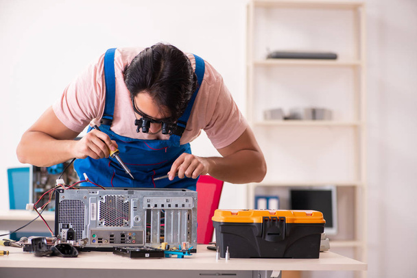 Молодой мужчина-подрядчик ремонта компьютера   - Фото, изображение