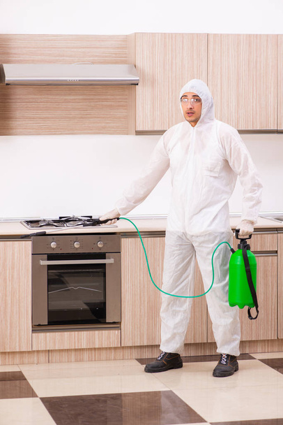 Professional contractor doing pest control at kitchen - Фото, изображение