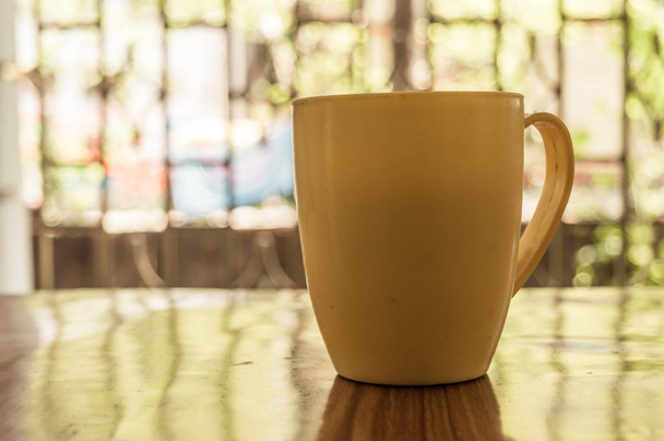 Close-up afbeelding van een kopje Cappuccino, mokka, latte, Americana, espresso hete koffie aroma voor op rustieke houten tafel achtergrond in cafe met achtergrond van zonlicht uit het raam in de ochtend. - Foto, afbeelding