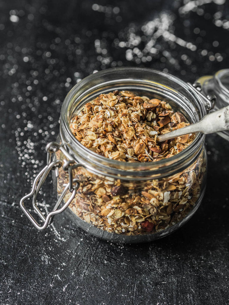 ナッツ、種子、室伏ベリー オープン ガラスの瓶にグラノーラです。健康的な朝食 - 黒地に jar の自家製グラノーラ - 写真・画像