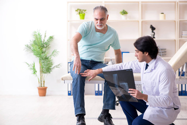 Old man visiting young male doctor  - Foto, Bild