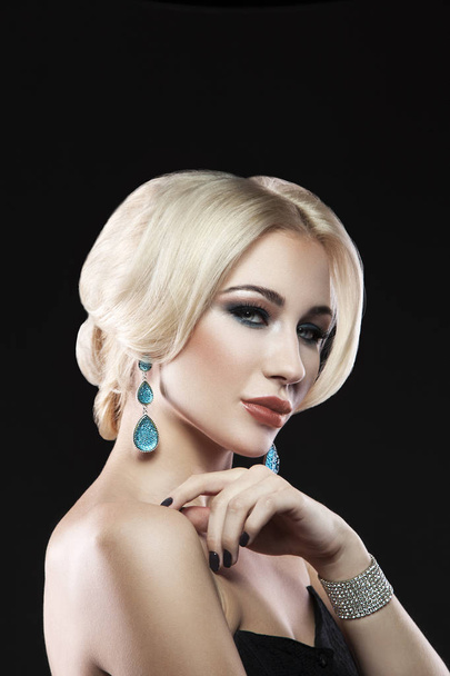 Porträt einer jungen blonden Frau mit trendigen Accessoires und stylischem Make-up auf schwarzem Hintergrund - Foto, Bild