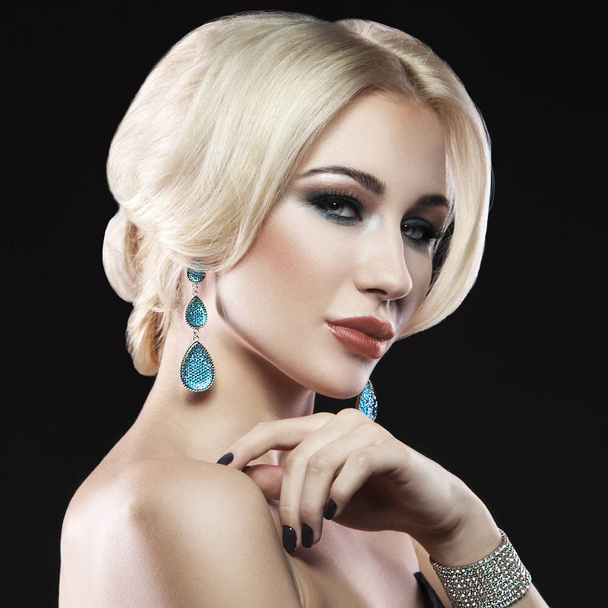 Portrait of young blonde woman with trendy accessories and stylish makeup posing on black background - Photo, Image