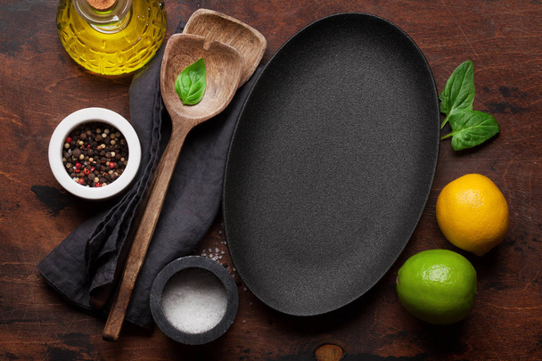 Кулінарія дерев'яного посуду, порожня тарілка, приправи та спеції на дерев'яному кухонному столі
 - Фото, зображення