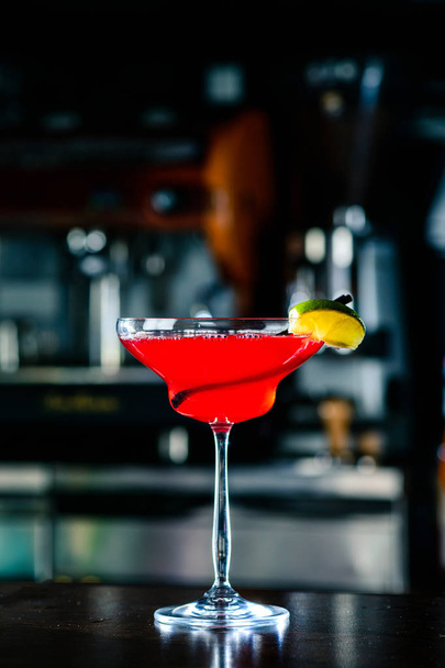 Cosmopolitan cocktail with lime on bar counter in a nightclub - Фото, зображення