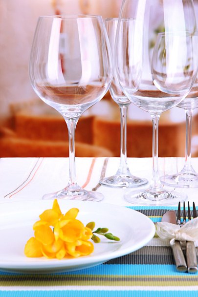 Table setting with glasses for different drinks on table on room background - 写真・画像