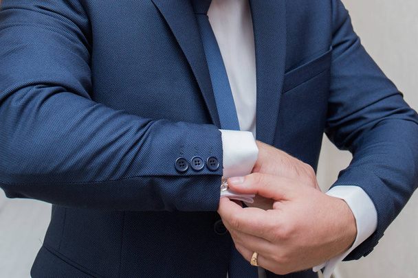 the groom fastens the cuffs of the sleeves on the shirt - Photo, image