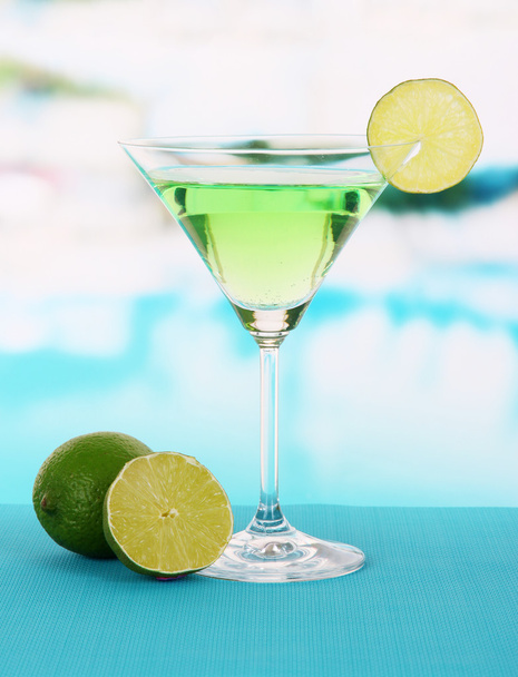 Green cocktail with lime on table on bright background - Foto, immagini