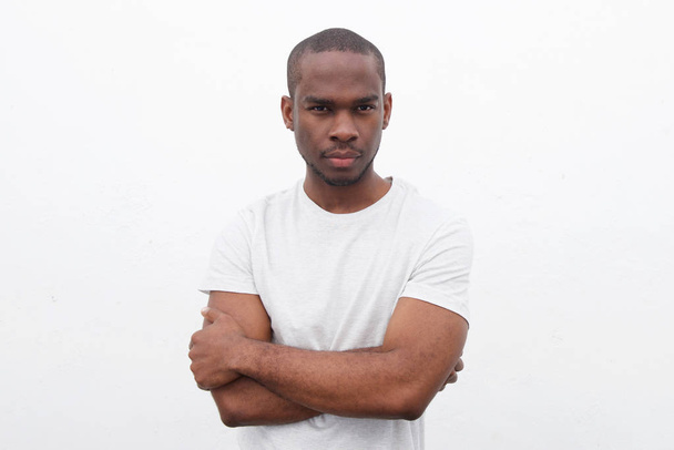 Csinos, fiatal fekete férfi pózol a fehér háttér keresztbe portréja  - Fotó, kép