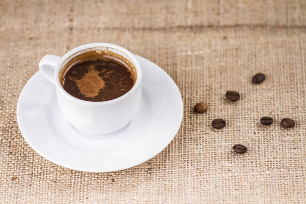 чашка ароматної кави на тлі мішковини
 - Фото, зображення