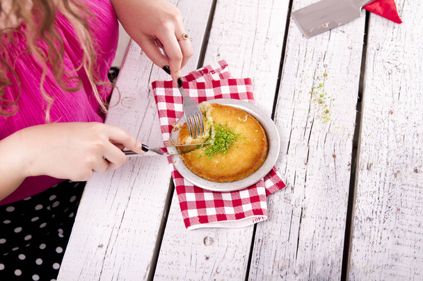 částečný pohled na ženu konzumní sýrový talíř na dřevěném stole - Fotografie, Obrázek