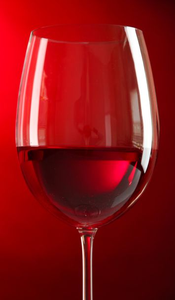 Glass of wine on red background - Photo, image