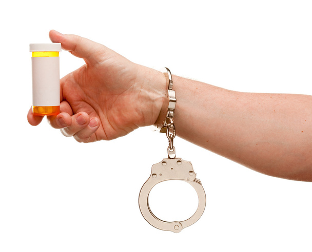 Hombre esposado sostiene botella de prescripción
 - Foto, imagen