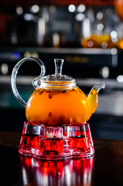 Sea buckthorn tea in glass teapot - Фото, изображение