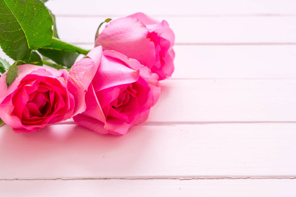 pink rose in vase on wood background - Φωτογραφία, εικόνα