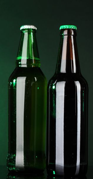 Bottles of beer on green background - Fotoğraf, Görsel