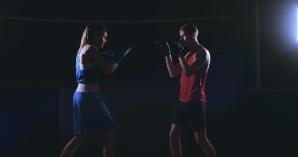 Кикбоксерша-спортсменка тренер по кикбоксингу тренирует женщин-друзей по фитнесу боксируя перчатки для фокуса наслаждаясь интенсивной тренировкой вместе в тренажерном зале вблизи
 - Кадры, видео