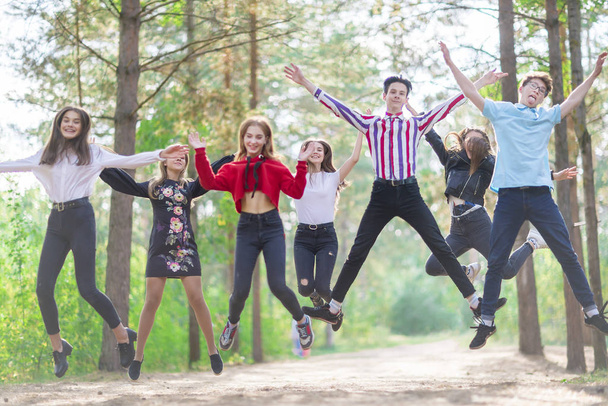 Cheerful jumping teens 15-19 years old in a playful mood in the  - Photo, Image