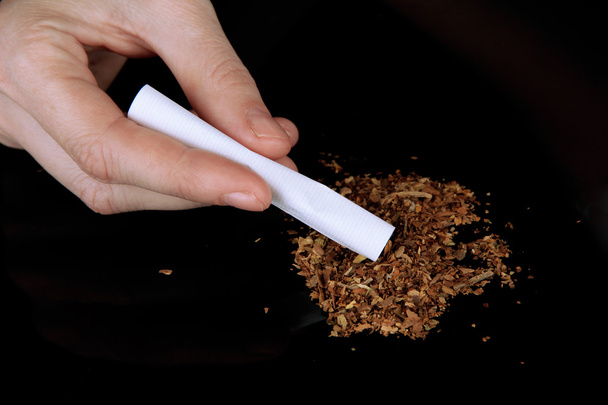 Руки делают сигарету изолированы на черном
 - Фото, изображение