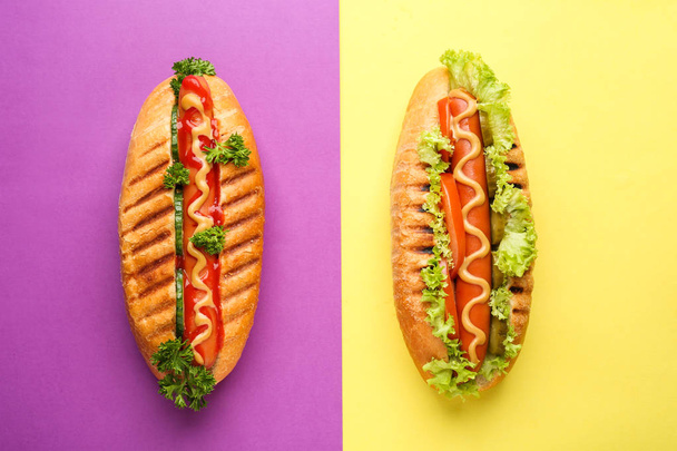 leckere Hotdogs auf farbigem Hintergrund - Foto, Bild
