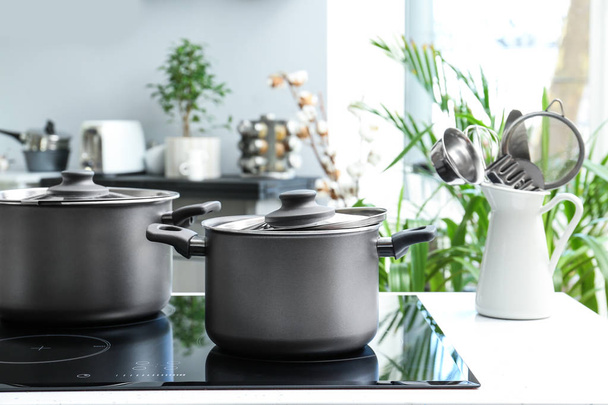 Saucepans on electric stove in kitchen - Photo, Image