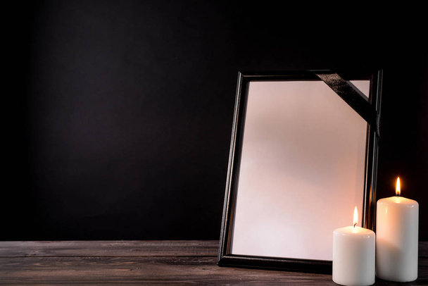 Prázdné pohřební rám a svíčky na stole černém pozadí - Fotografie, Obrázek