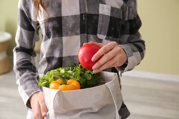 Mujer joven con verduras frescas en bolsa ecológica, primer plano
 - Foto, imagen