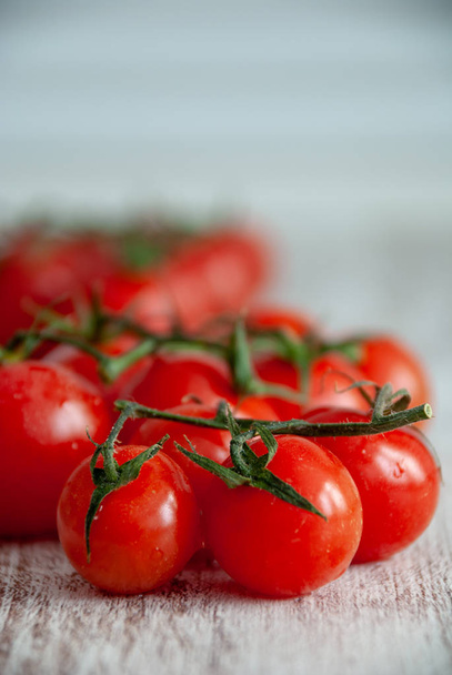 Detail červené cherry rajčat ve svislém na rozostřeného pozadí Dřevěná bílá - Fotografie, Obrázek