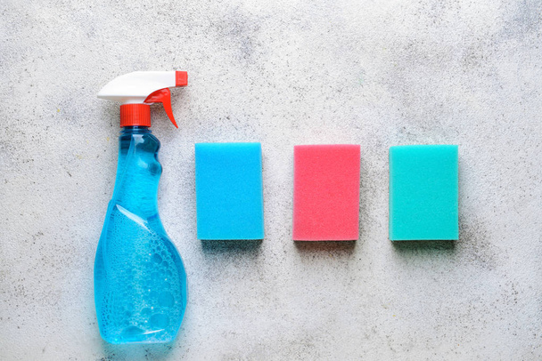 Bottle with detergent and sponges on grey background - Foto, afbeelding