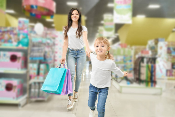 Семейные покупки. Мать и ребенок гуляют по торговому центру
. - Фото, изображение