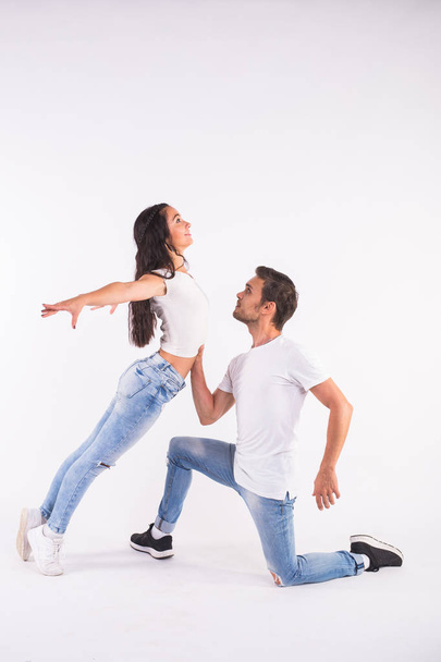 Young couple dancing social dance bachata, merengue, salsa, kizomba. Two elegance pose on white room. - Valokuva, kuva
