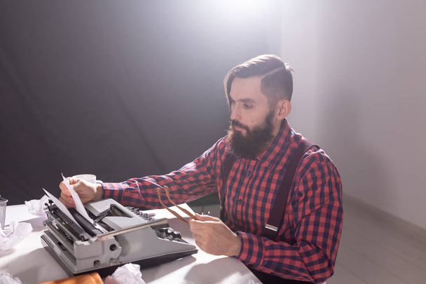 People, retro style and technology concept - High angle view of bearded writer in plaid shirt with typewriter - Fotó, kép