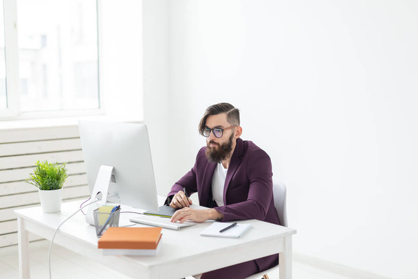 Menschen und Technologie-Konzept - attraktiver Mann mit Bart, gekleidet in lila Jacke, der am Computer arbeitet - Foto, Bild