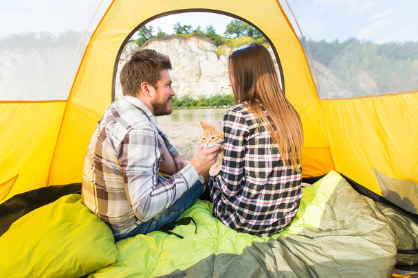 people, summer tourism and nature concept - young couple resting in camping tent, view from inside - Photo, Image