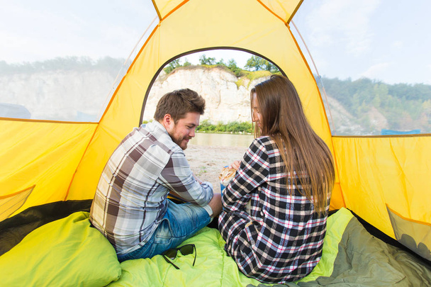 ihmiset, kesämatkailu ja luonto konsepti - nuori pari lepää teltassa, näkymä sisältä
 - Valokuva, kuva