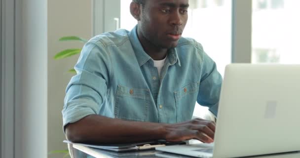 Afrikanischer amerikanischer Geschäftsmann schreibt Notizen mit Blick auf Laptop-Monitor im Büro - Filmmaterial, Video