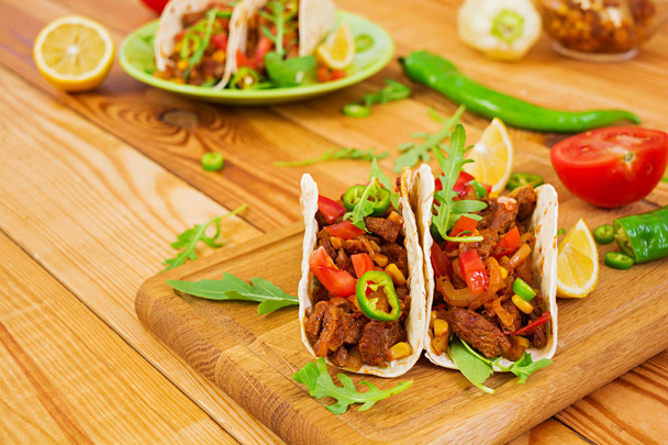 Tacos mexicanos con carne de res en salsa de tomate
 - Foto, Imagen