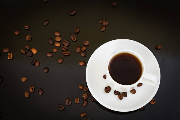 кофейная чашка и кофейные зерна на темном фоне
 - Фото, изображение